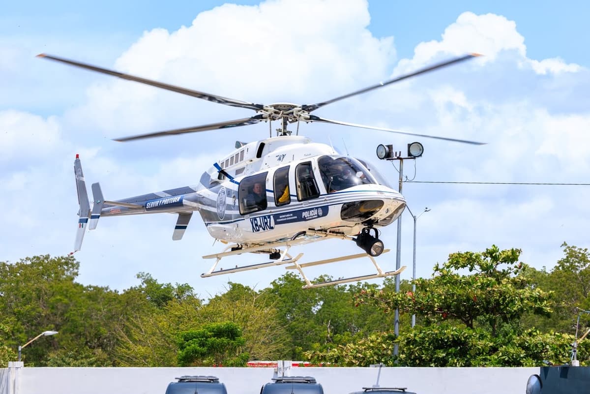 Helicóptero de la policía en vuelo sobre zona boscosa durante operativo de control.